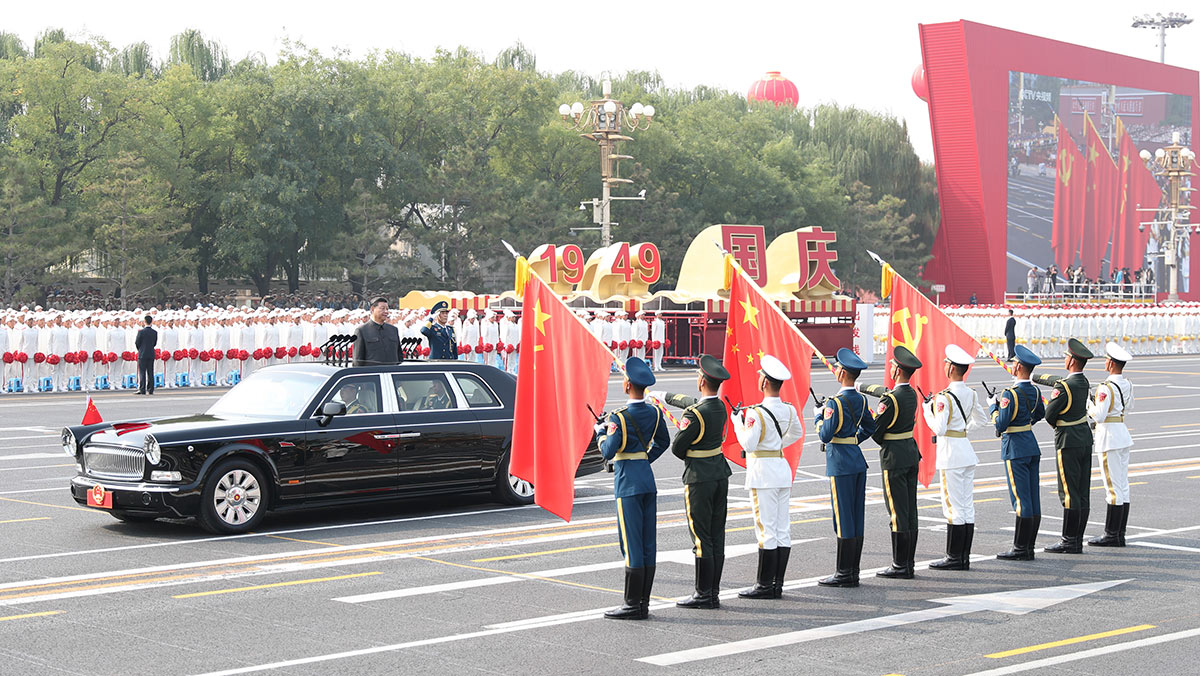 習(xí)近平驅(qū)車行進(jìn)至黨旗、國旗、軍旗前，向旗幟行注目禮