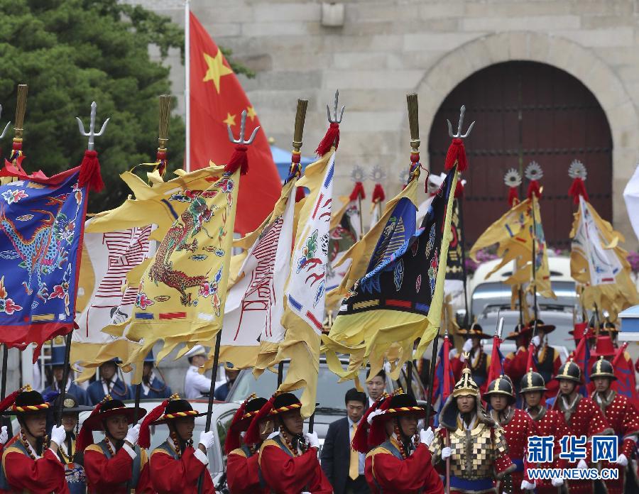 7月3日，韓國總統(tǒng)樸槿惠在青瓦臺總統(tǒng)府舉行隆重儀式，歡迎中國國家主席習近平對韓國進行國事訪問。這是習近平的車隊在身著民族服裝的韓國禮儀隊伍引導下駛?cè)肭嗤吲_。新華社記者丁林攝  